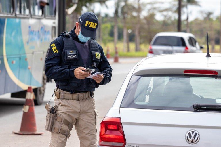Policial verifica documentos em fiscalização (Foto: Divulgação PRF)